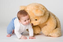 Little boy and yellow bear on white