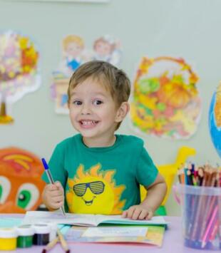 child in classroom with art supplies