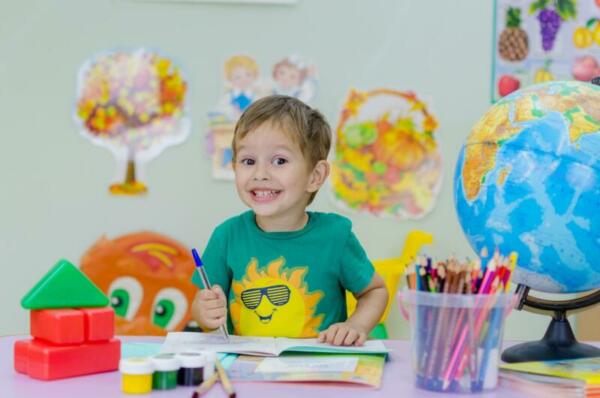 child in classroom with art supplies