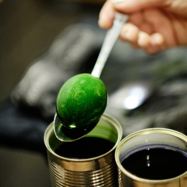 Two old tins are used for dying a hard boiled Easter egg.