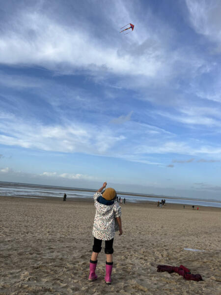 Kind am Strand mit Drachen